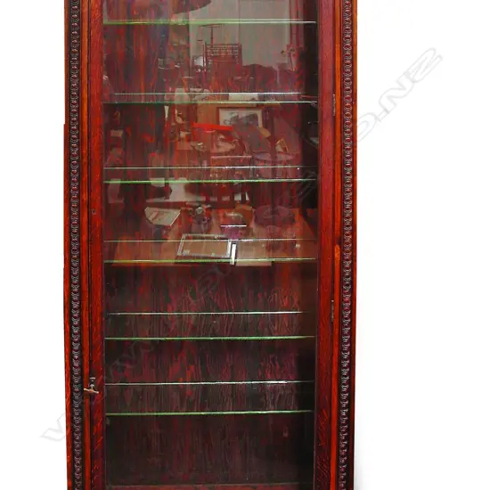 An early 20thC oak tall narrow glazed display cabinet