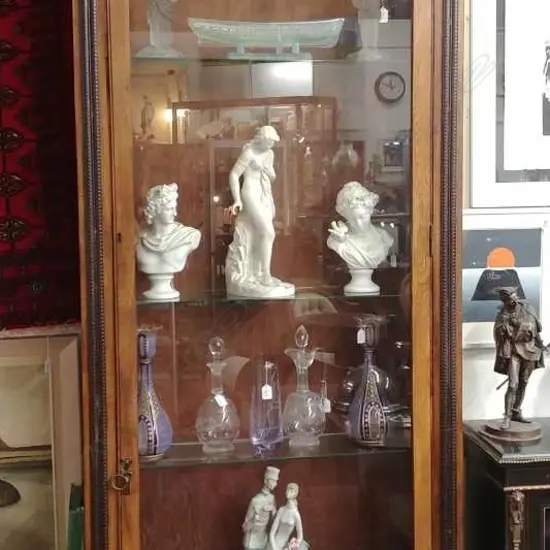 An early 20thC oak tall narrow glazed display cabinet