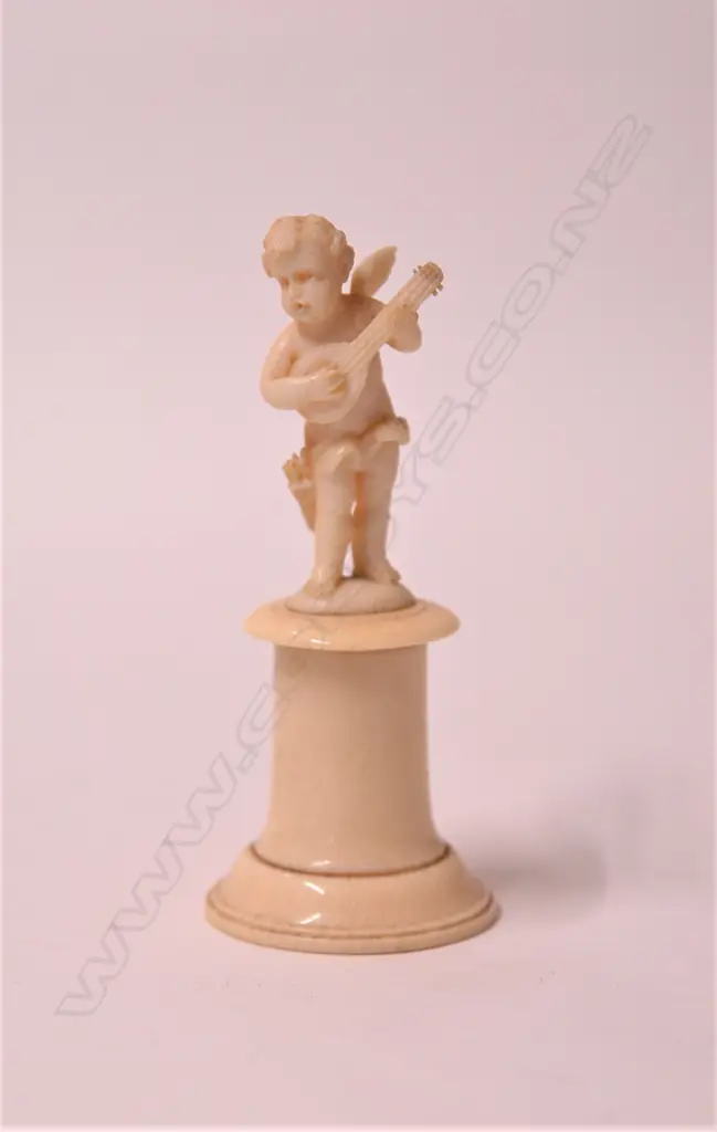 A small 19thC ivory carving of a cherub musician Image 1++