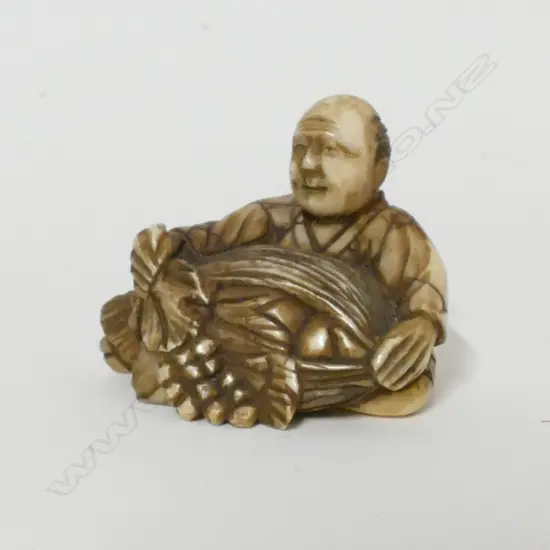 A small old ivory netsuke of a man