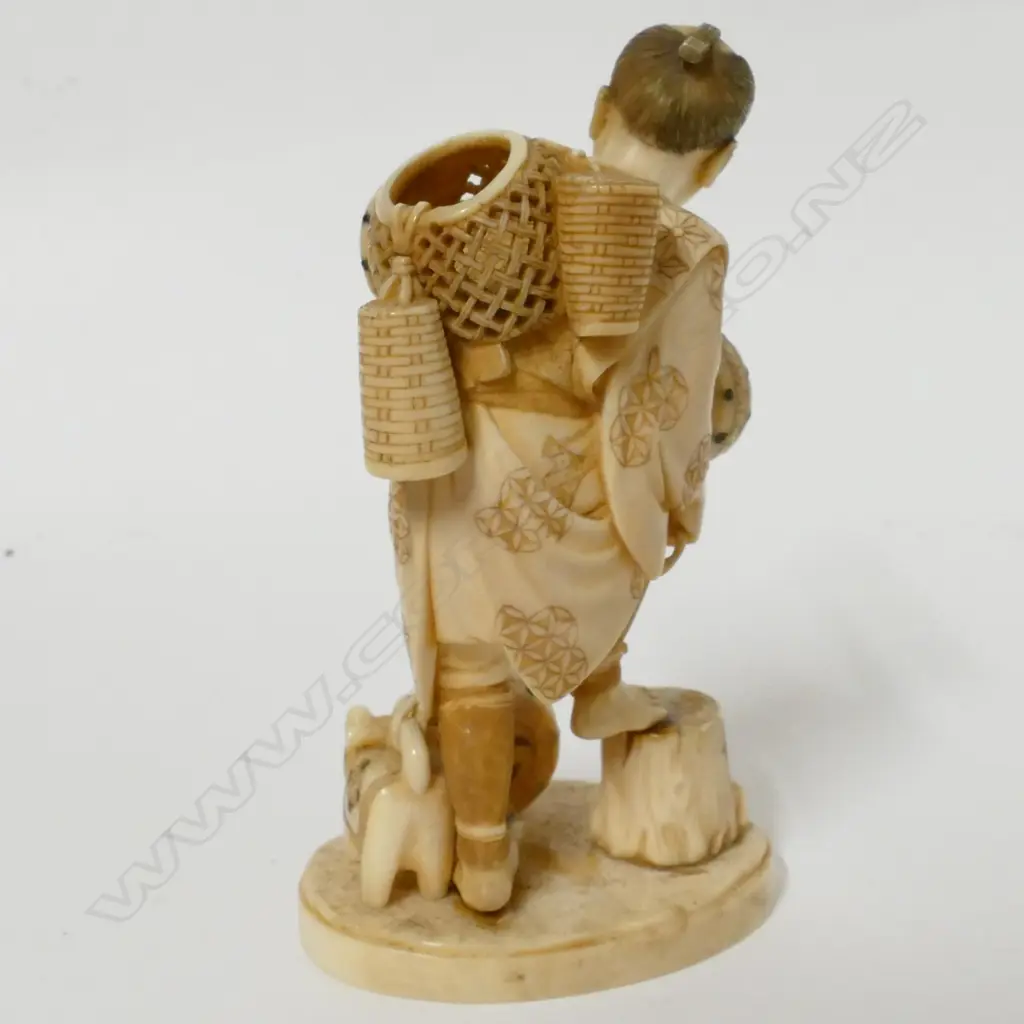 A Japanese Meiji period ivory okimono of a drum and basket seller Image 1++