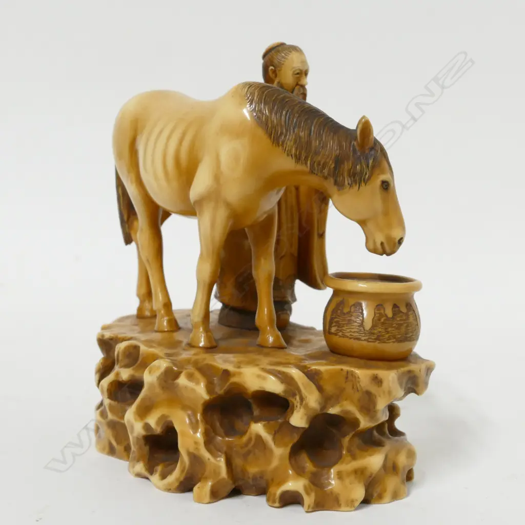 A 19thC ivory okimono of a man watering a horse Image 1++