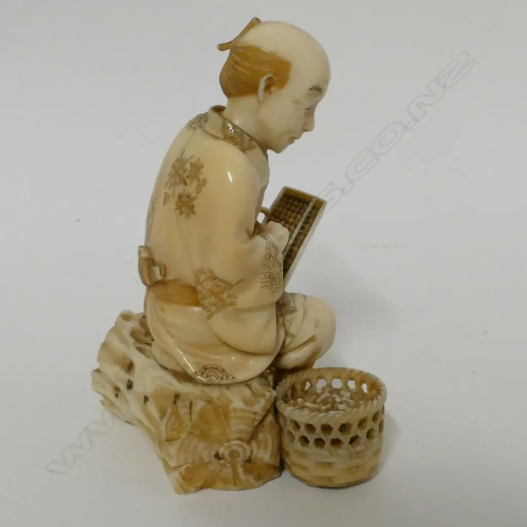 A Japanese Meiji period ivory okimono of a peanut merchant Image 1++