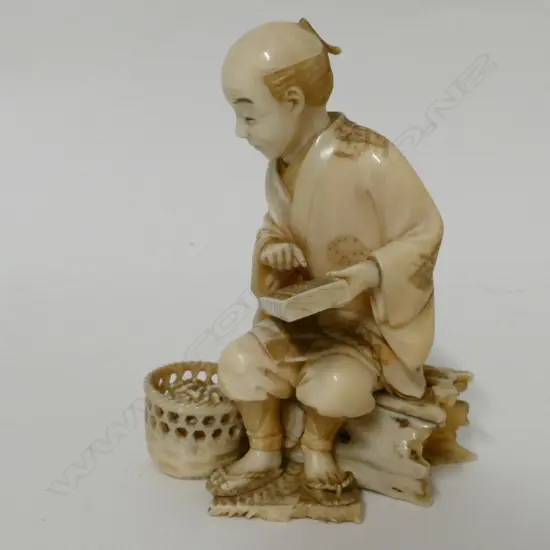 A Japanese Meiji period ivory okimono of a peanut merchant