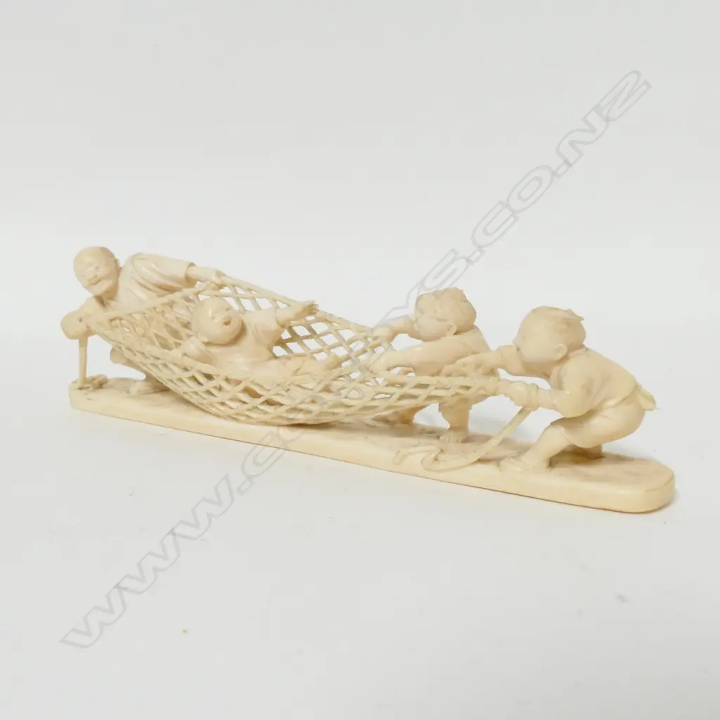 A Meiji period Japanese carved ivory okimono of a man and children playing Image 1++
