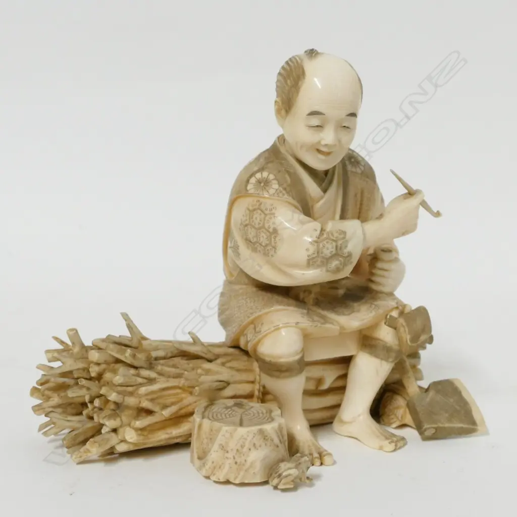 A Japanese Meiji period ivory okimono of a woodsman seated to smoke his kiseru pipe Image 1++