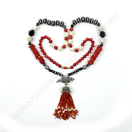 A long decorative necklace of red coral beads