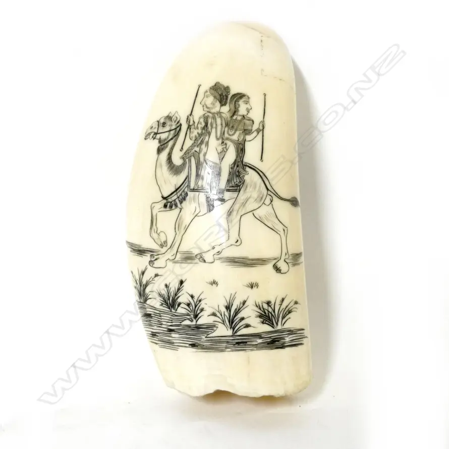 A 20thC scrimshaw whale's tooth depicting an amorous Indian couple riding upon a camel Image 1++