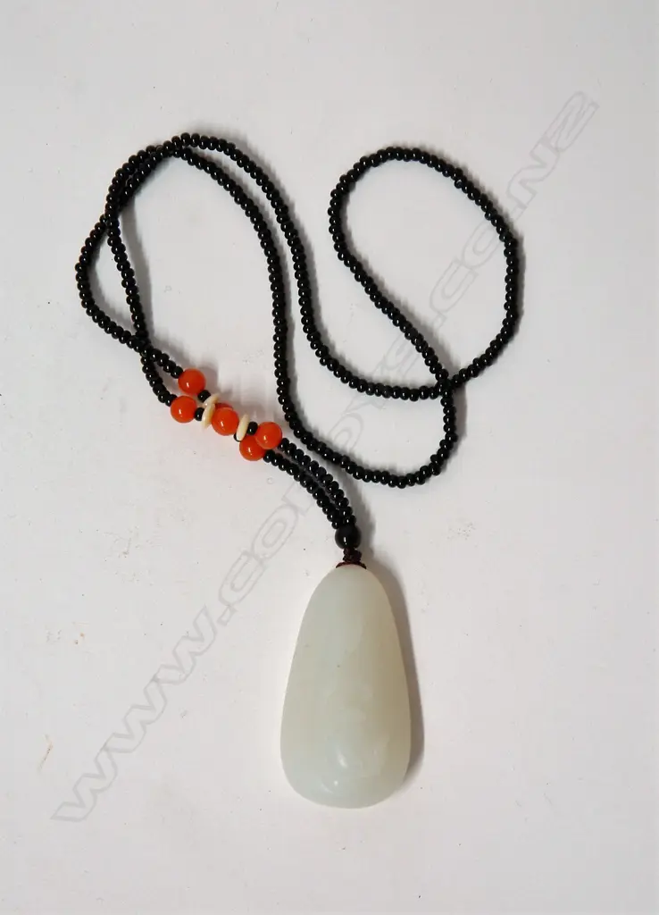 A Chinese pale carved jadeite pendant on bead necklace Image 1++