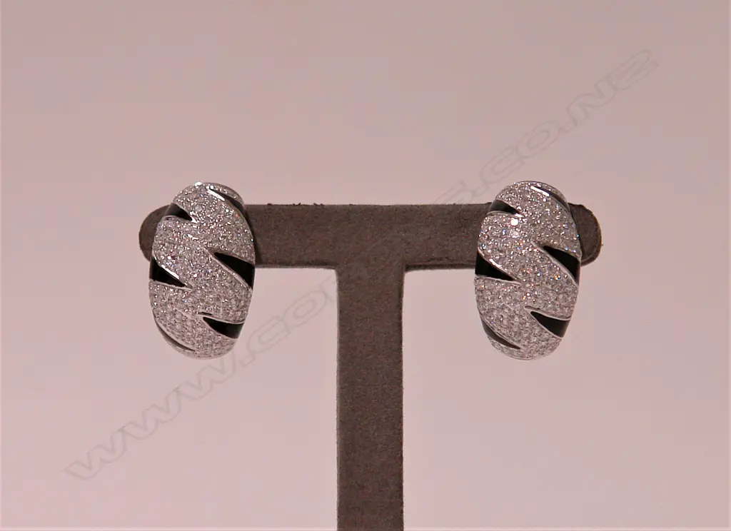 A pair of lady's modern 18ct. white gold and diamond wide curved and tapered earrings Image 1++