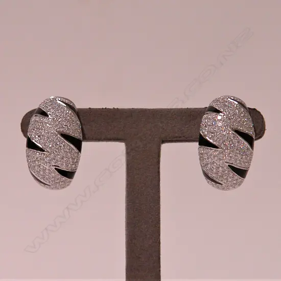 A pair of lady's modern 18ct. white gold and diamond wide curved and tapered earrings