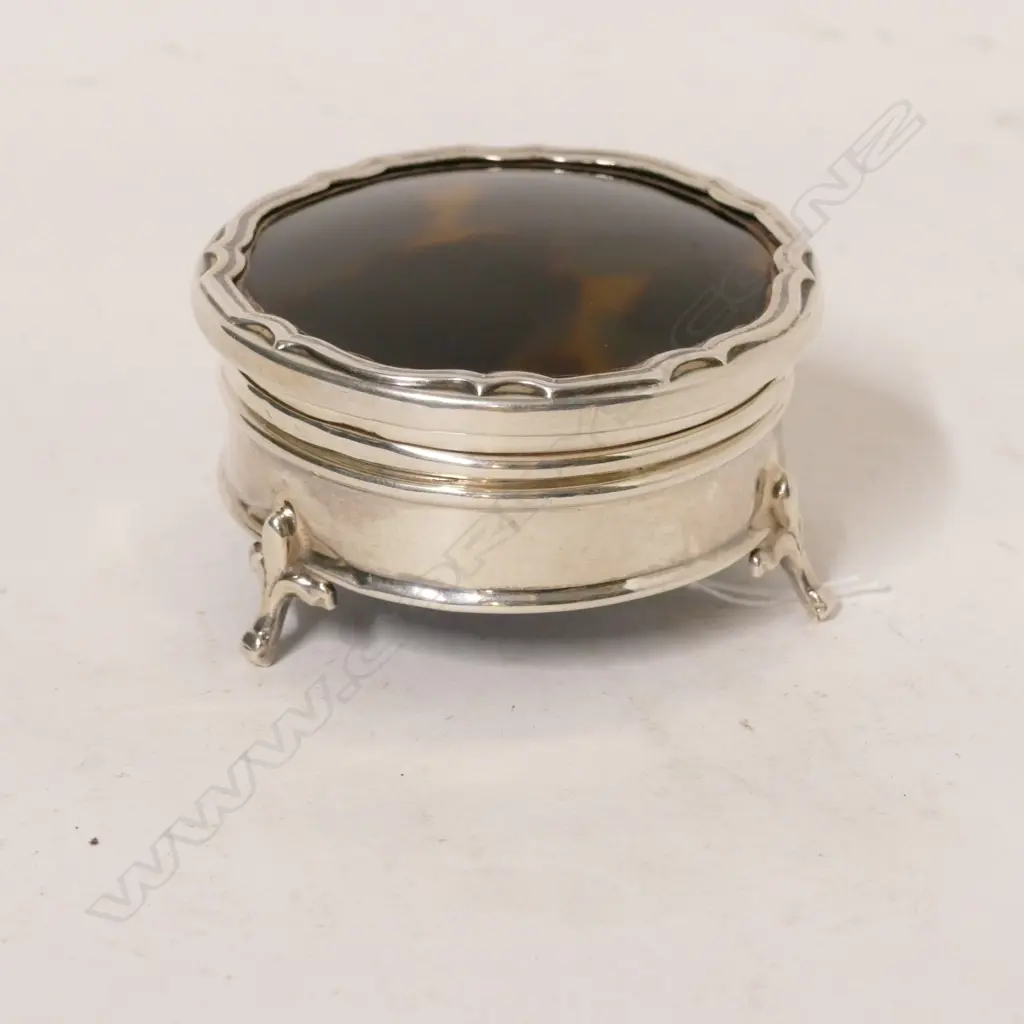 A tortoiseshell lidded circular silver jewellery box with blue velvet lining Image 1++