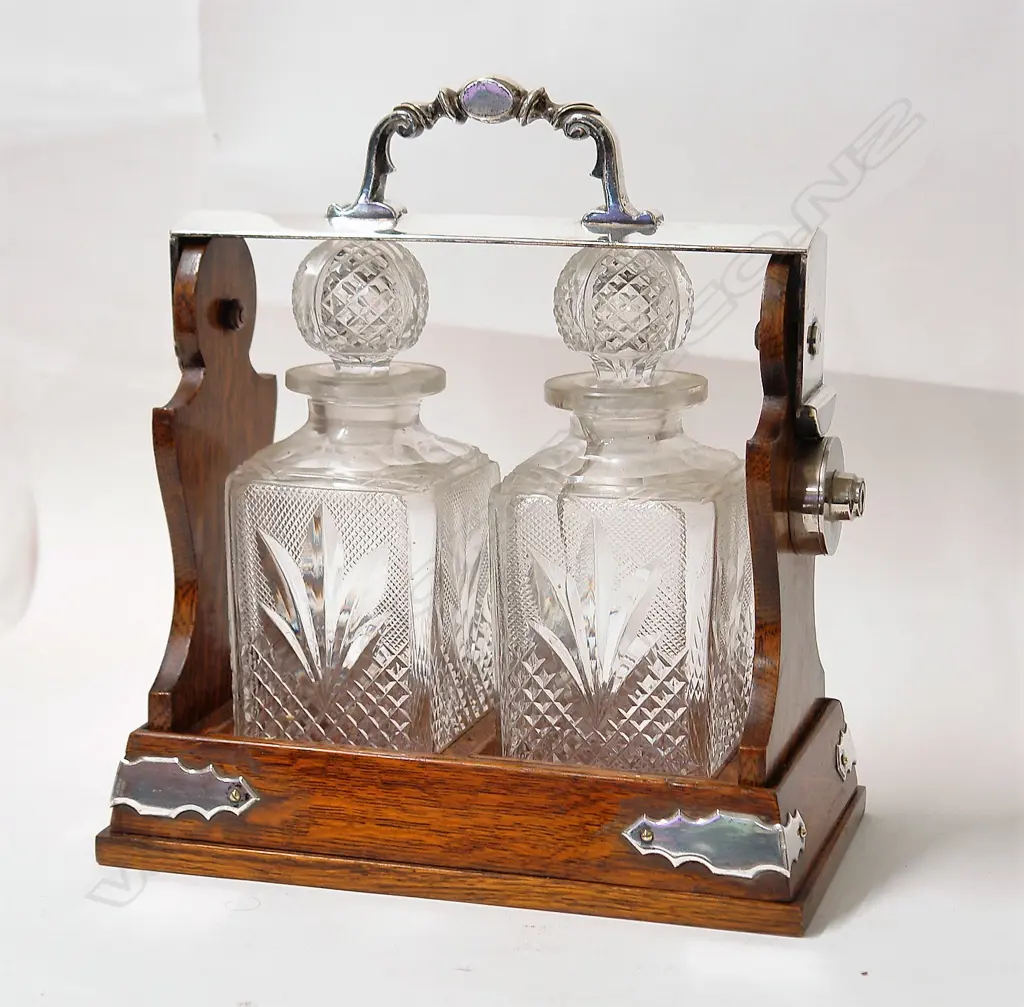 An Edwardian oak and silver plate two crystal bottle tantalus Image 1++
