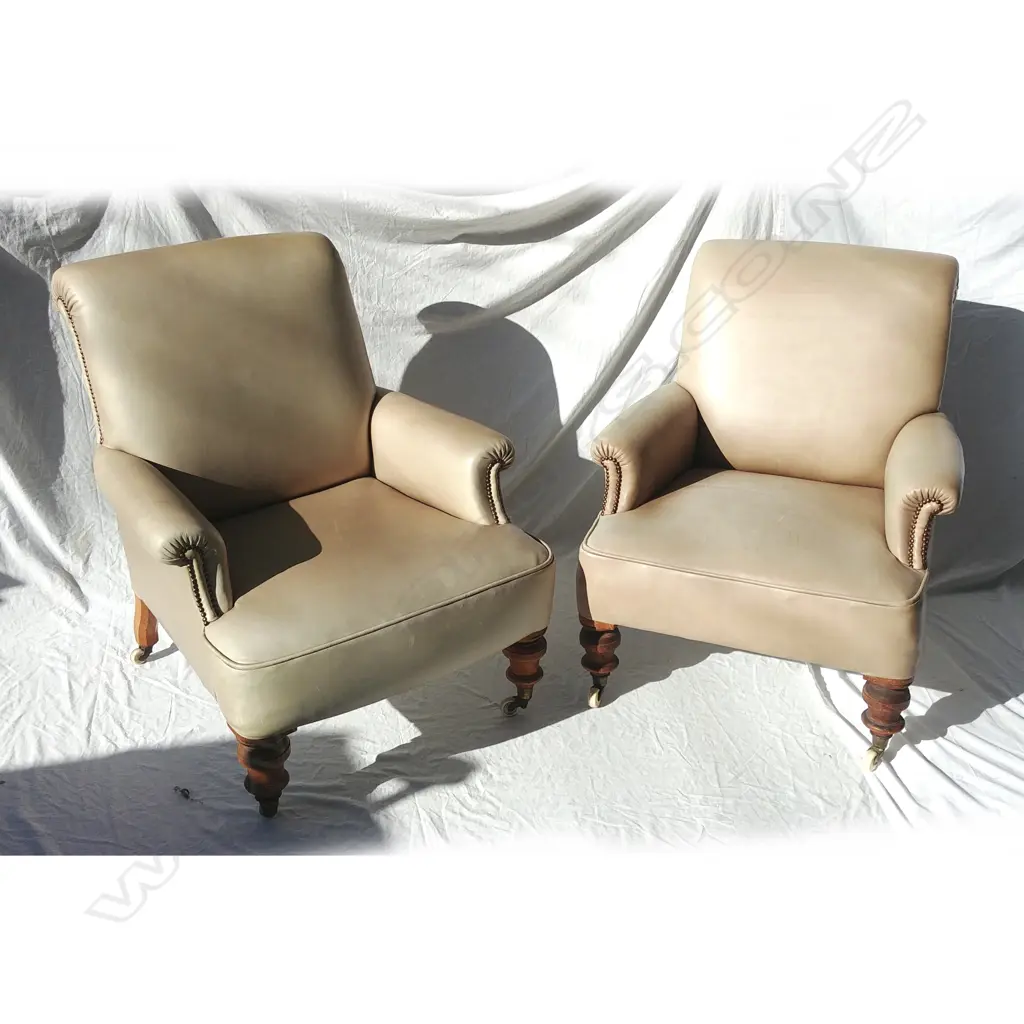 A pair of Victorian mushroom coloured leather armchairs of plain design with roll arms Image 1++