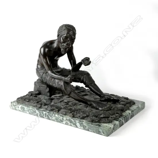 A bronze figure of a seated South African bushman holding pipe