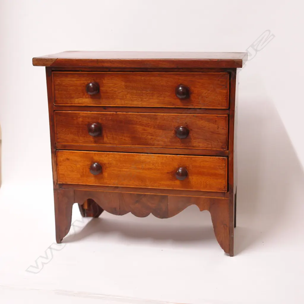 A Georgian walnut and mahogany miniature chest of drawers Image 1++