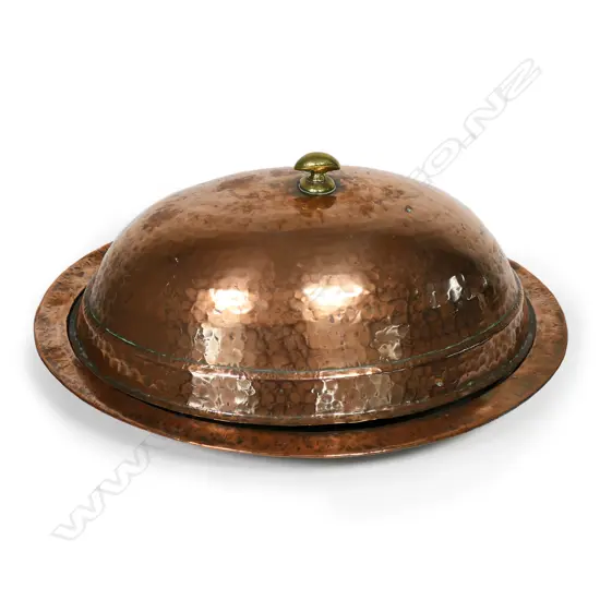 An antique copper serving platter and cover,