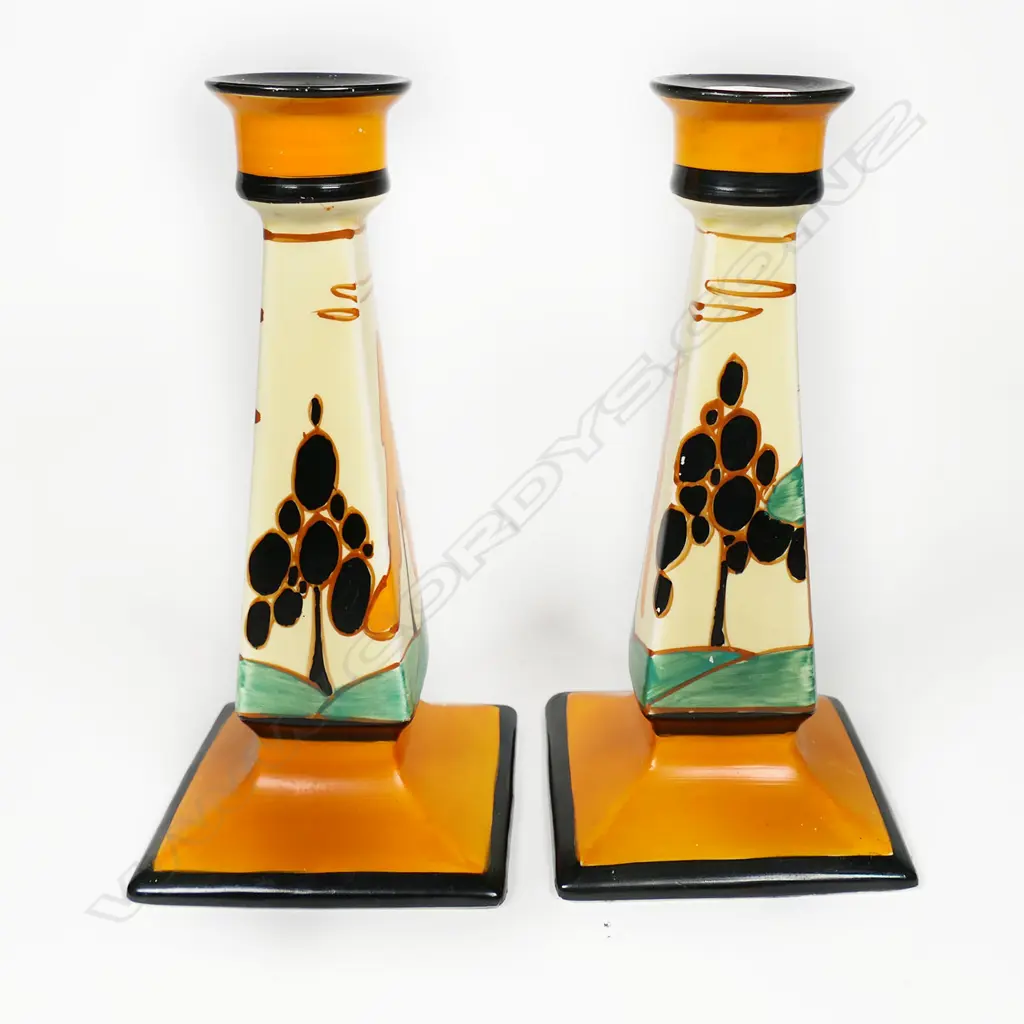 A pair of Clarice Cliff Bizarre orange 'Trees and House' candlesticks, Image 1++