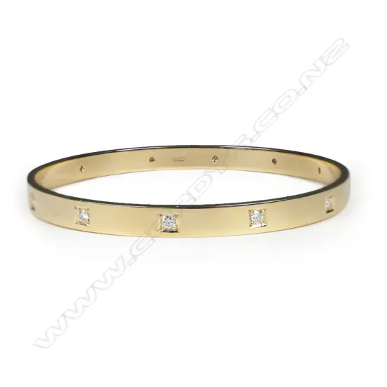 A modern 9ct yellow gold and diamond set bangle,