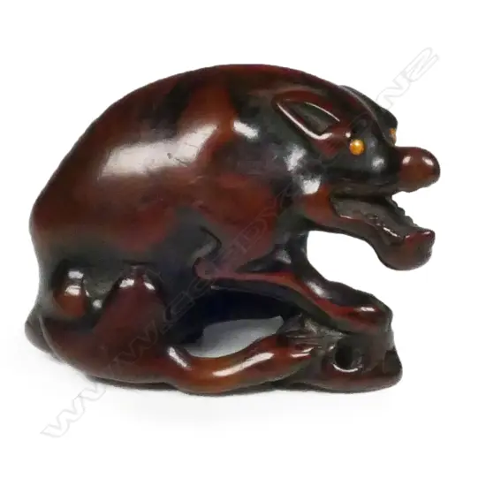 An old carved wood netsuke of a starving wolf,