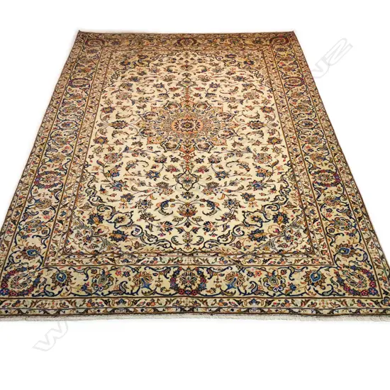 A fine quality hand-knotted Kashan carpet, the field decorated with multi-coloured flowering leafy tendrils surrounding a central medallion, on an ivory ground, multiple border guards with conforming decoration. 3400 x 2450mm.