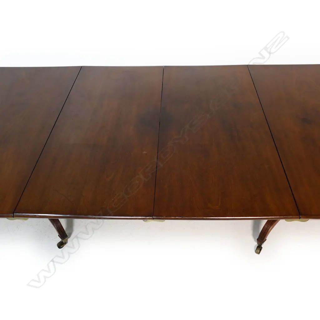 A Regency mahogany double pedestal dining table - with two extension leaves, brass casters. 1500 x 1300 x 730mm (2620mm when extended). Image 1++