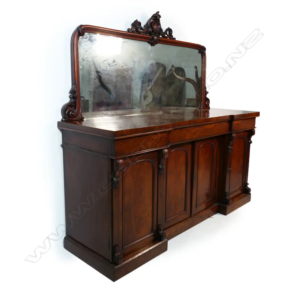 A quality Victorian mahogany mirror back sideboard - carved detail to the mirror back, the base with three drawers over a central cupboard, the side doors open to reveal shelves with one side containing a cellarette, raised on plinth base. 1820 x 580 x 1800mm. Some heat and/or water damage to the top. Image 1++