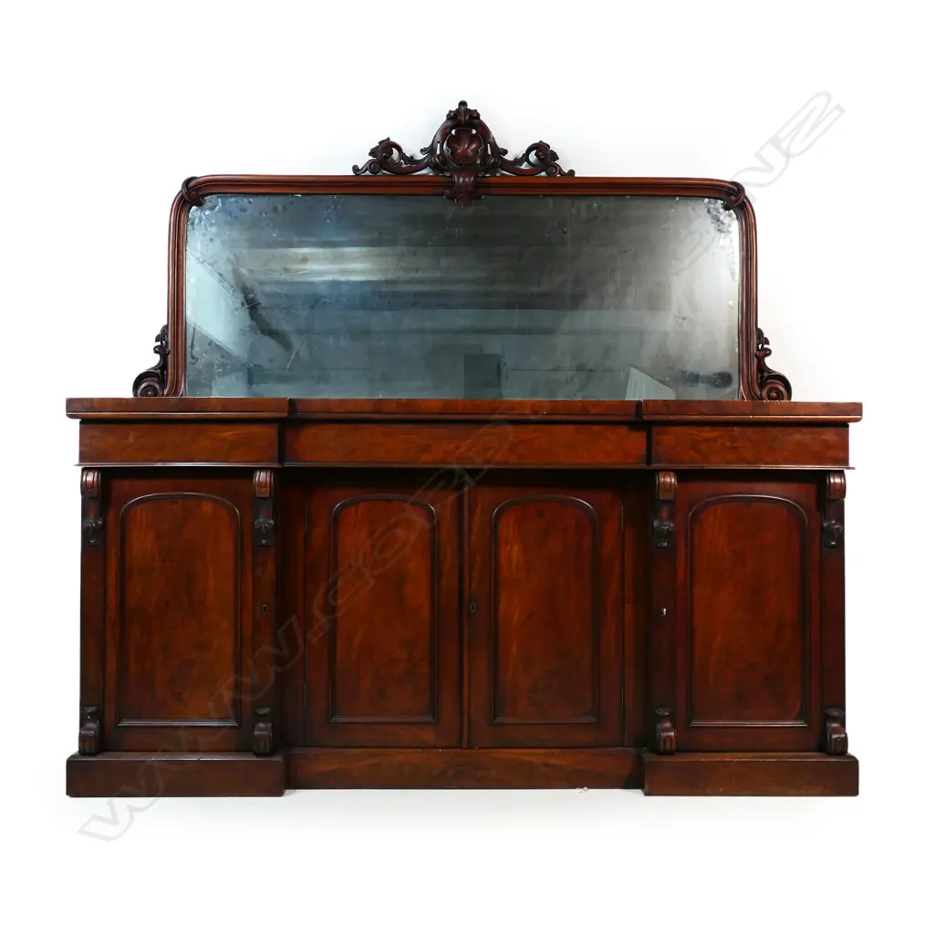A quality Victorian mahogany mirror back sideboard - carved detail to the mirror back, the base with three drawers over a central cupboard, the side doors open to reveal shelves with one side containing a cellarette, raised on plinth base. 1820 x 580 x 1800mm. Some heat and/or water damage to the top. Image 1++