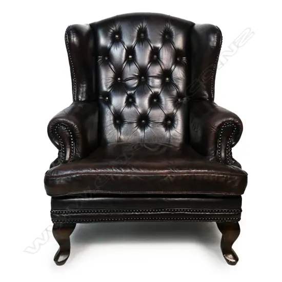 An antique style leather wing back chair,