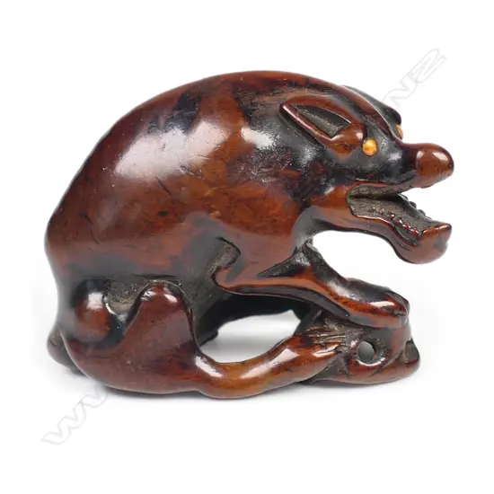An old carved wood netsuke of a starving wolf,