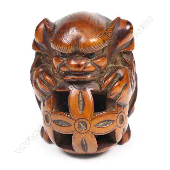An early 19thC wood netsuke study of a shishi,