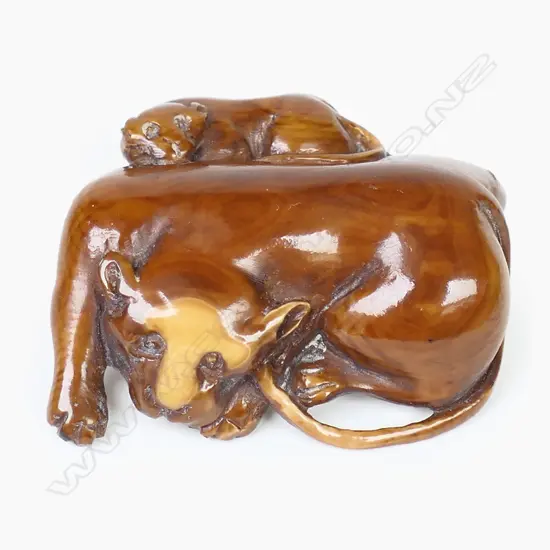 An ivory netsuke study of a lion with a cub,