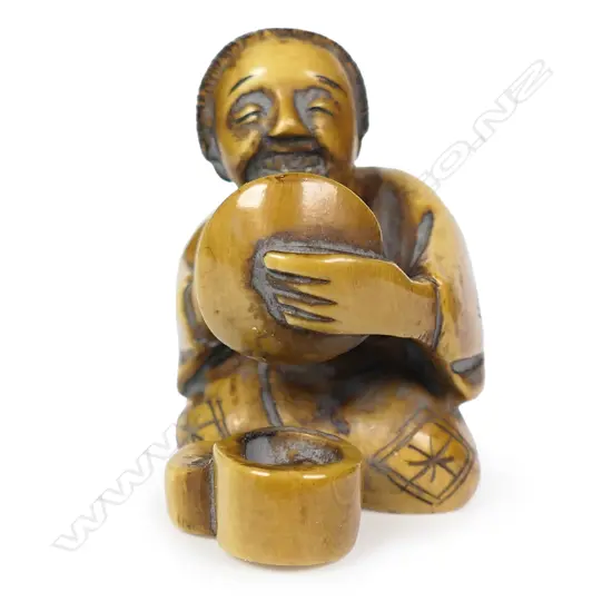 An ivory netsuke of a kneeling woman,