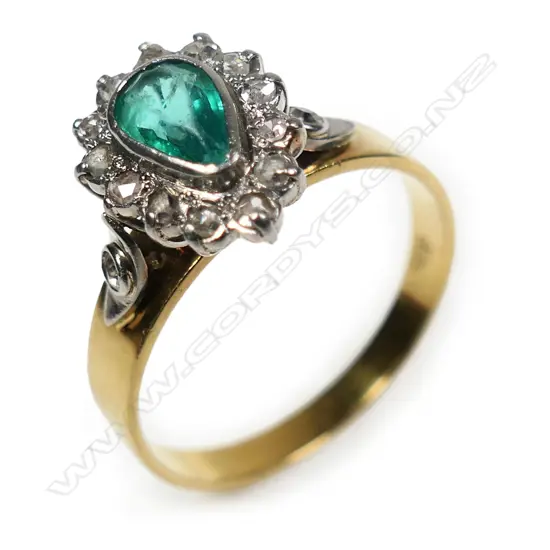 An 18ct white and yellow gold emerald and diamond cluster ring,
