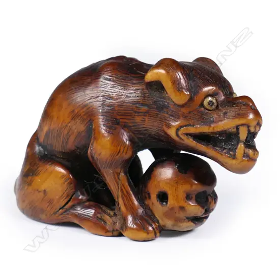 An 18thC Edo period carved boxwood wolf netsuke signed Tomotada,