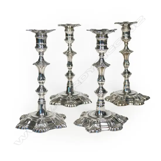 A rare set of four early George III cast silver candlesticks,