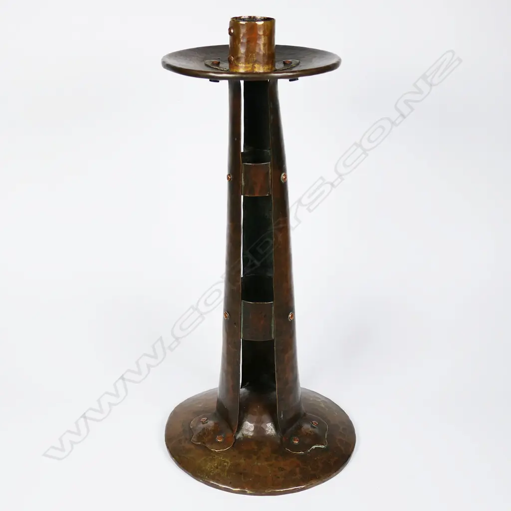 An Arts and Crafts hammered copper candlestick by Arthur John Seward, Image 1++