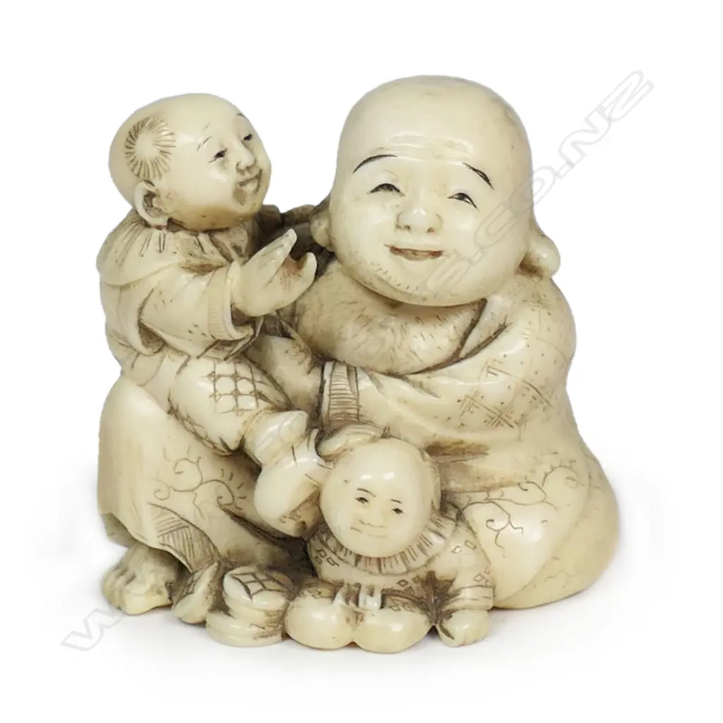 A Meiji Japanese carved ivory okimono of a gent with two young children, finely detailed and stained. Signed to the base. H.45mm. Provenance: From the collection of Gerry and Valerie Bermel (of Travis Antiques. Wellington 1950's to 1986). Image 1++