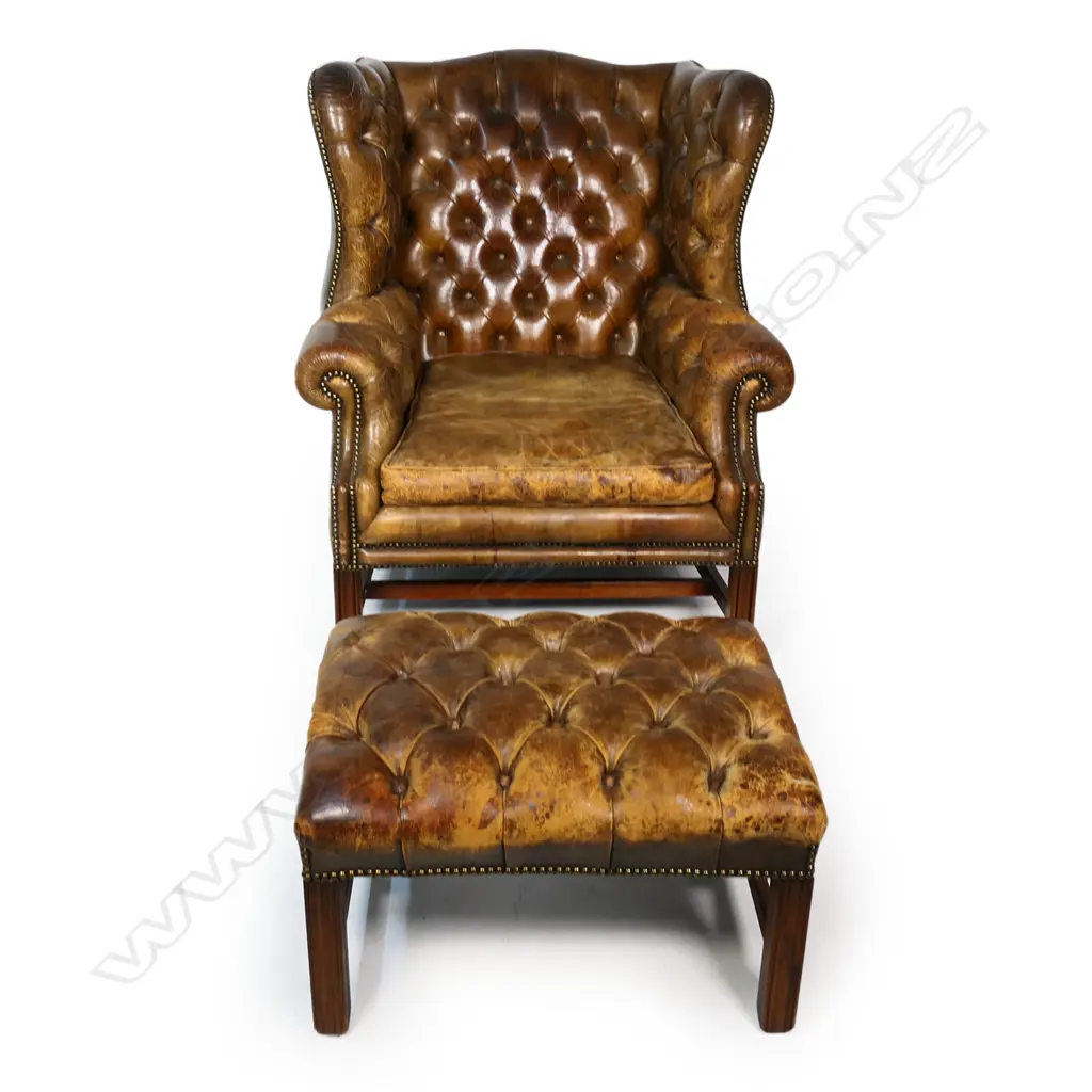 A leather button back wing back armchair and footstool, Image 1++