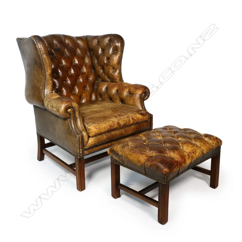 A leather button back wing back armchair and footstool, Image 1++