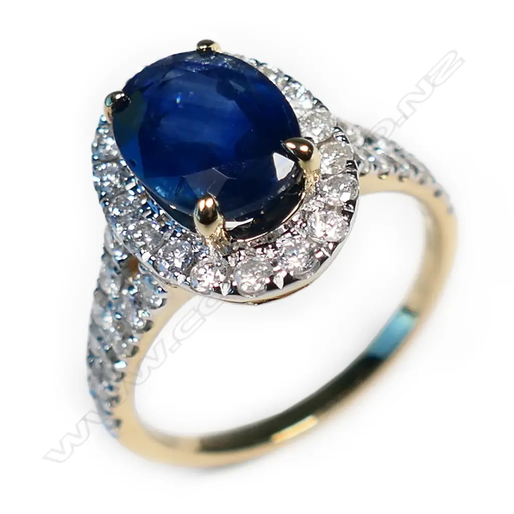 A 14ct gold sapphire and diamond halo ring, Image 1++