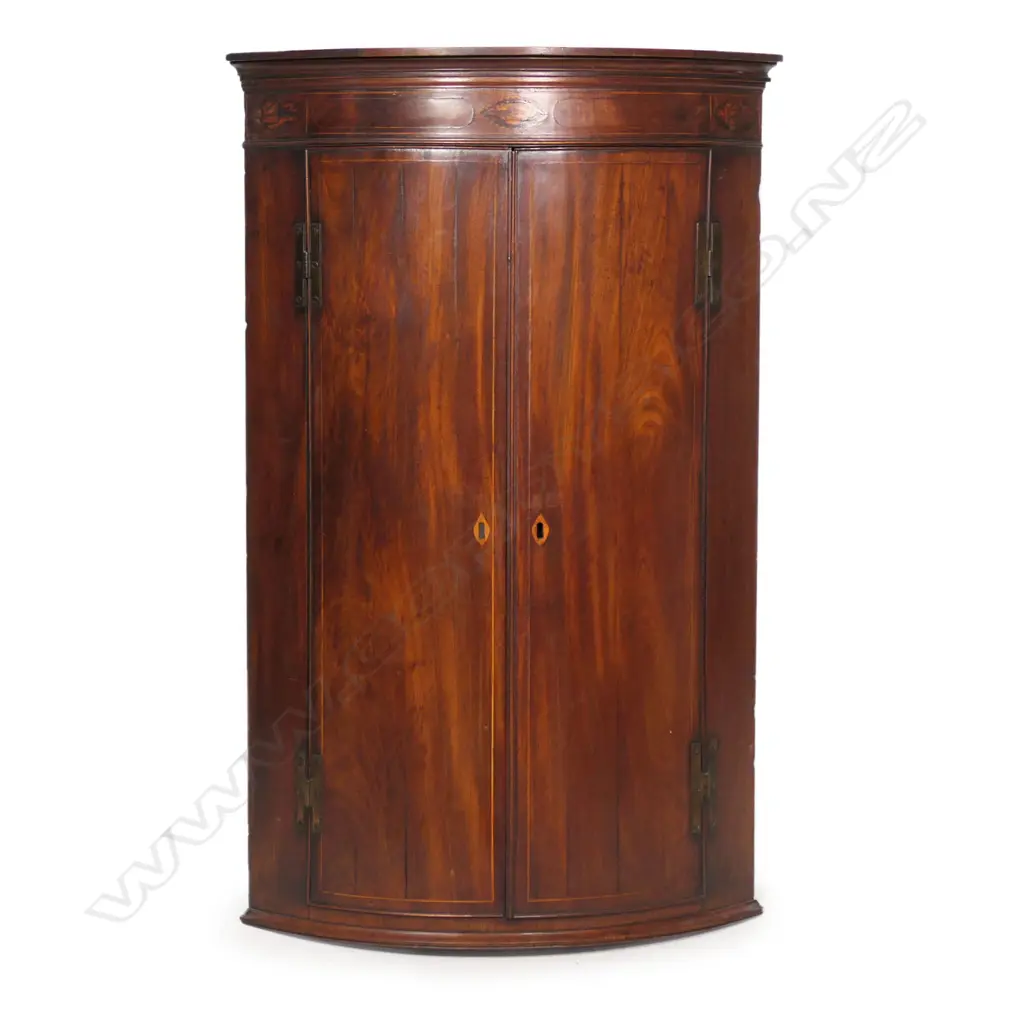 A Georgian mahogany Sheraton style corner cabinet, inlaid stringing, to doors and pediment with shell detail, three shelves to the painted interior. 800 x 460 x 1100mm. Image 1++