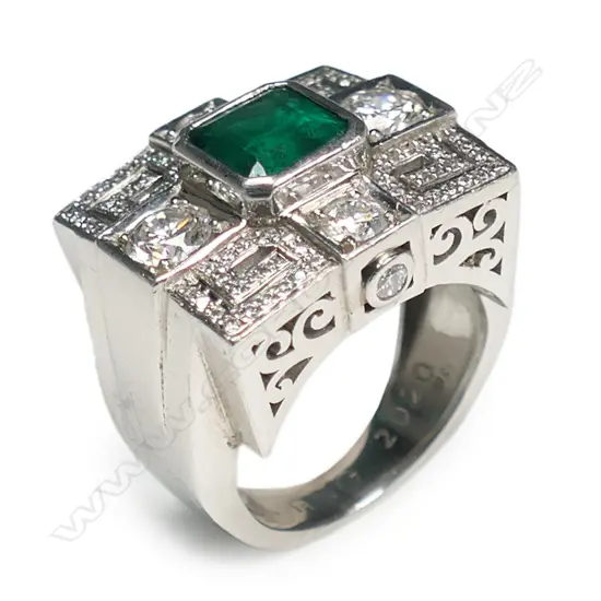 An impressive platinum emerald and diamond dress ring,