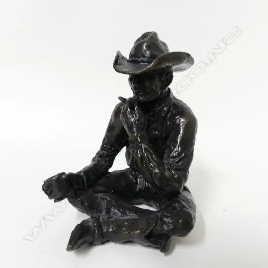 A small original bronze figure of a seated cowboy