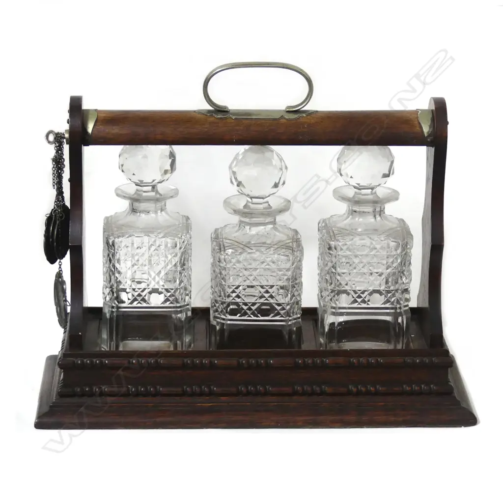 An Edwardian oak three bottle tantalus Image 1++