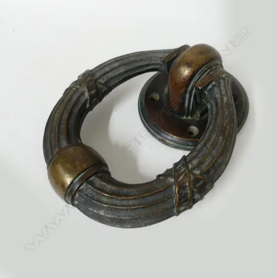 A heavy old bronze door knocker of traditional design