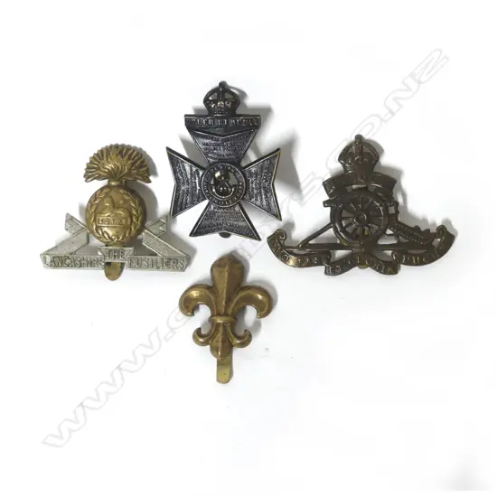 A collection of four old army hat badges