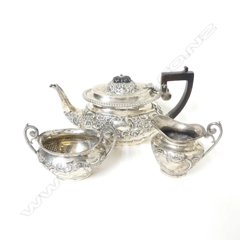 An Edwardian period ornately embossed silver three-piece tea set Image 1++