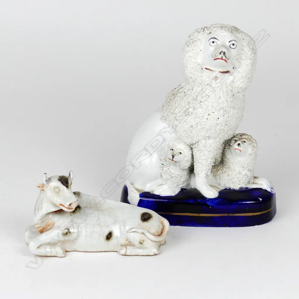 A Victorian Staffordshire dog group ornament and similar recumbent cow Image 1++