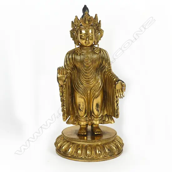 A gilded bronze standing buddha statuette